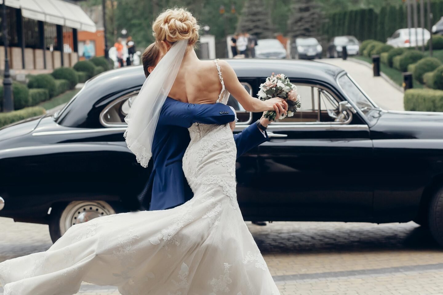 Luxury wedding couple dancing at old car in light
