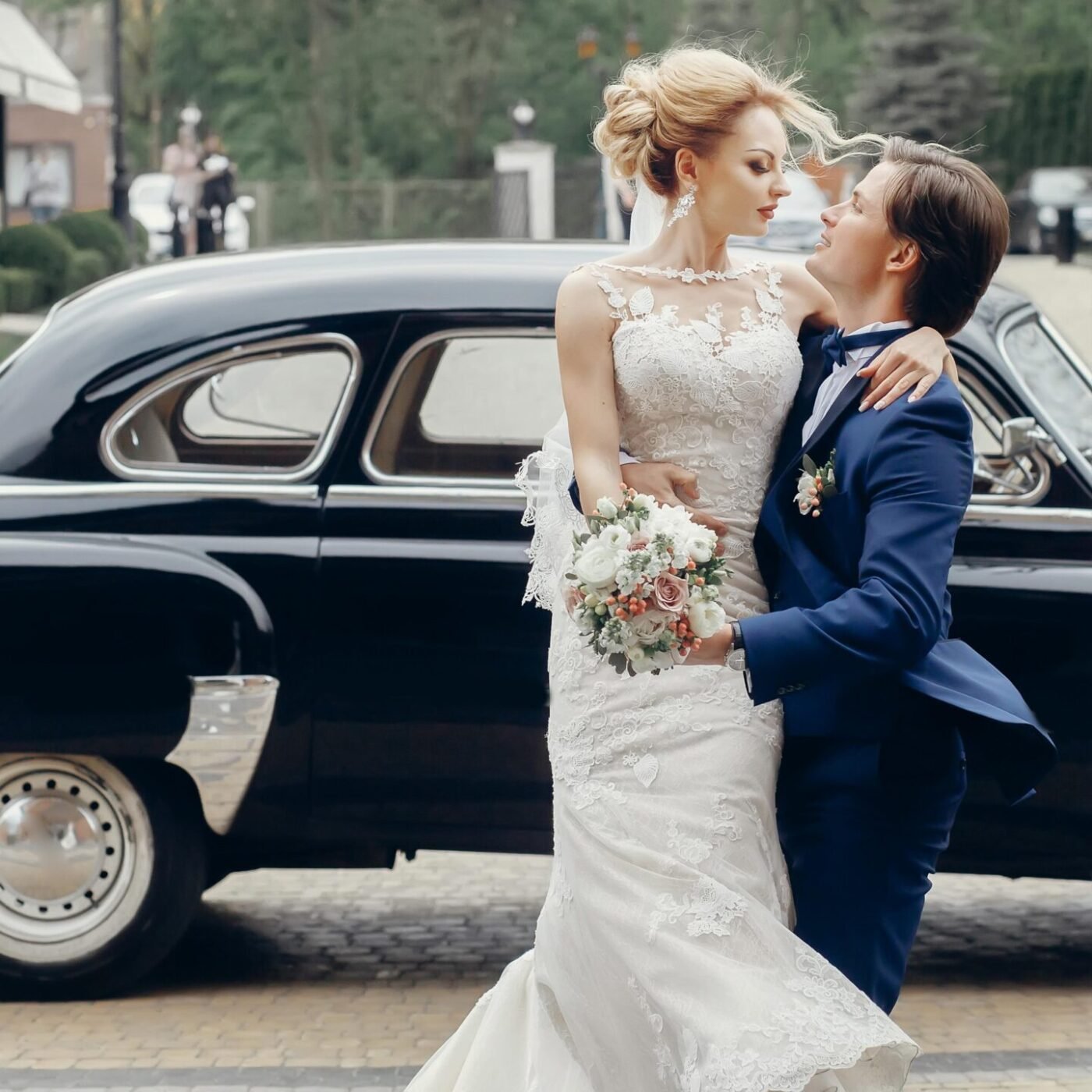 Luxury wedding couple dancing at old car in light